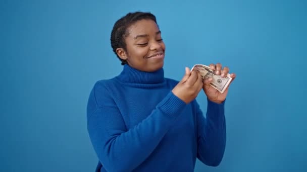 Африканська Американка Усміхається Впевнено Тримає Гроші Над Ізольованим Синім Фоном — стокове відео