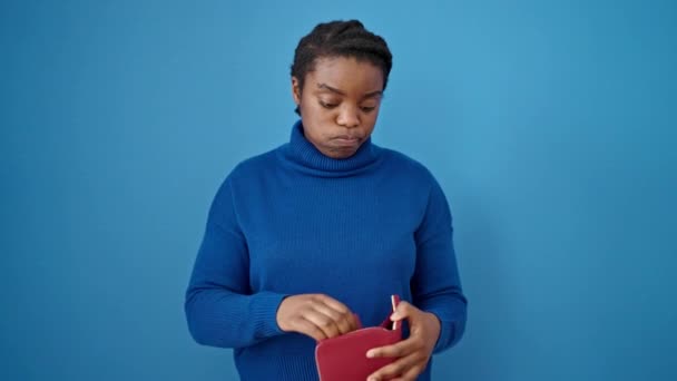 在孤立的蓝色背景下露出空皮夹的非裔美国女人 — 图库视频影像