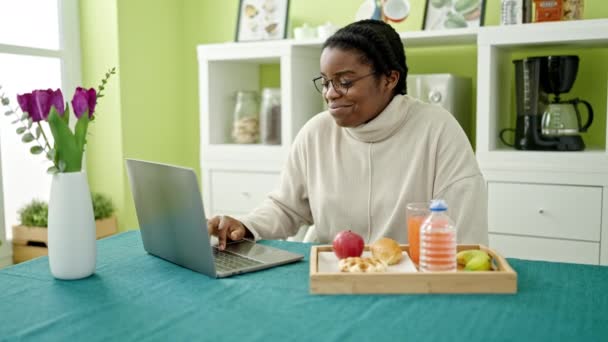 Afroamerykanka Jedząca Śniadanie Przy Użyciu Laptopa Jadalni — Wideo stockowe