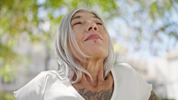 中世灰色の髪の女性が公園で腕を開いて呼吸 — ストック動画