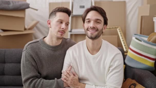 Двое Мужчин Сидят Диване Обнимаются Целуясь Новом Доме — стоковое видео