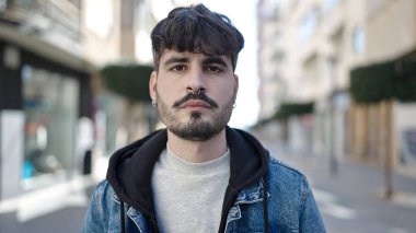 Sokakta ciddi bir ifadeyle duran İspanyol genç adam.