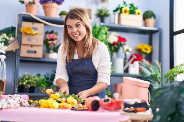 Young woman florist make bouquet of flowers at florist