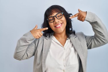 Hispanic woman standing over isolated background smiling cheerful showing and pointing with fingers teeth and mouth. dental health concept. 