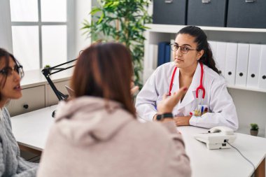 Three woman doctor and patients having medical consultation at clinic