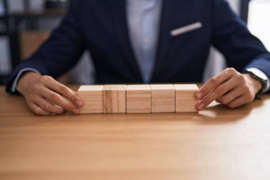 Ofiste tahta küplerle masada oturan genç sarışın bir iş adamı.