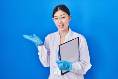 Bilim adamlarının laboratuvarında çalışan Çinli genç bir kadın avuç içlerini açıp fotokopi alanını gösteriyor. 