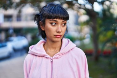 Parkta rahat bir ifadeyle duran genç bir kadın.