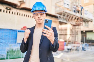 Young hispanic man architect having video call at street