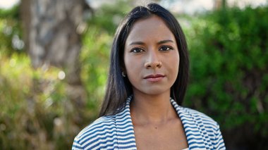 African american woman standing with serious expression at park