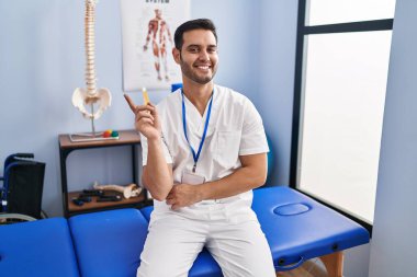 Sakallı, sakallı, yüzünde kocaman bir gülümseme olan ve kameraya bakan genç bir İspanyol adam.. 