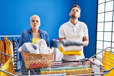 İspanyol anne ve oğlu çamaşır ipine asılmış. Kameraya bakıp öpüşüyorlar. Sevimli ve seksi oluyorlar. aşk ifadesi. 