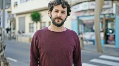 Sokakta ciddi bir ifadeyle duran İspanyol genç adam.