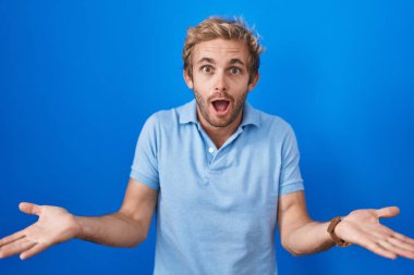 Mavi arka planda duran beyaz bir adam gülümseyen, yardım eli uzatan ve kabul eden biri.. 