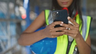 Sokakta akıllı telefon kullanan Afrikalı Amerikalı kadın müteahhit.