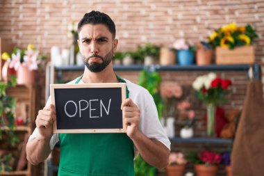 Çiçekçide çalışan İspanyol genç adam elinde açık tabela tutuyordu. Depresyondaydı ve sıkıntıdan endişe ediyordu. Kızgın ve korkmuştu. hüzünlü ifade. 