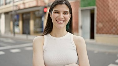 Sokakta kolları çapraz duran genç, güzel İspanyol kadın.