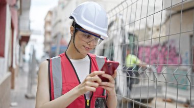 Sokakta akıllı telefon kullanan genç, güzel İspanyol bir inşaatçı.