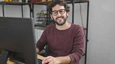Young hispanic man business worker using computer working at office