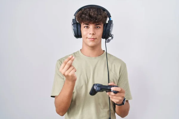 Adolescente Hispânico Jogando Vídeo Game Segurando Controlador Fazendo Gesto Dinheiro — Fotografia de Stock