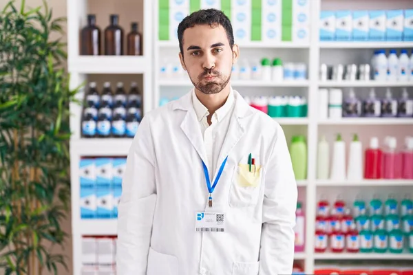 Handsome Hispanic Man Working Pharmacy Drugstore Puffing Cheeks Funny Face — Stock Photo, Image