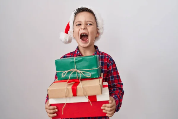 Pequeño Niño Hispano Con Sombrero Navidad Sosteniendo Regalos Enojado Loco —  Fotos de Stock