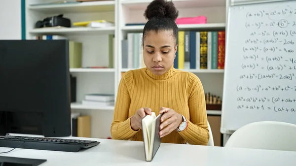 若いアフリカ系アメリカ人の女性が図書館で本を読んでいる — ストック写真