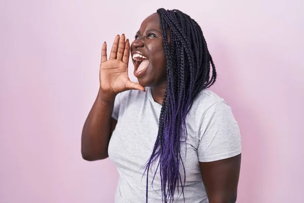 Молодая Африканская Женщина Стоящая Розовом Фоне Кричащая Громко Сторону Рукой — стоковое фото