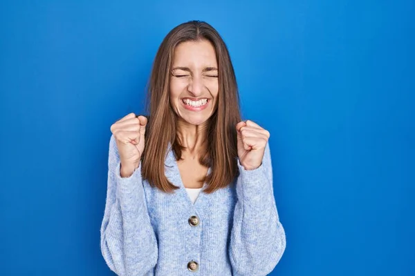 Young Woman Standing Blue Background Excited Success Arms Raised Eyes — ストック写真