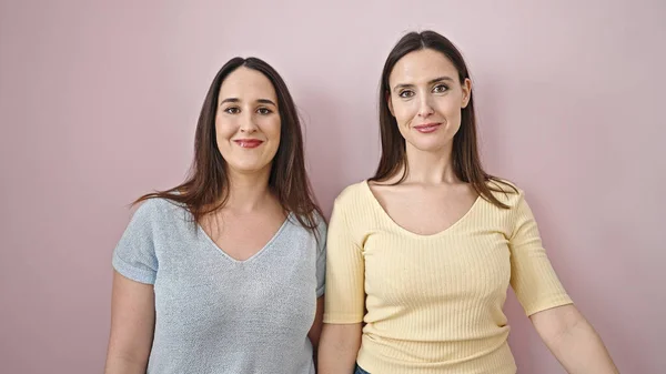 Twee Vrouwen Glimlachen Vol Vertrouwen Samen Staan Geïsoleerde Roze Achtergrond — Stockfoto