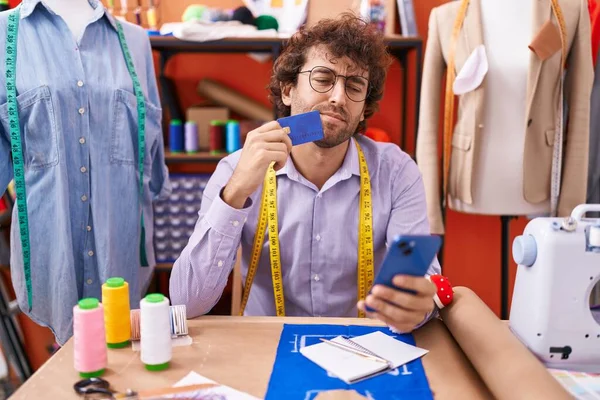 Young Hispanic Man Tailor Using Smartphone Credit Card Doubt Expression — Stock Photo, Image