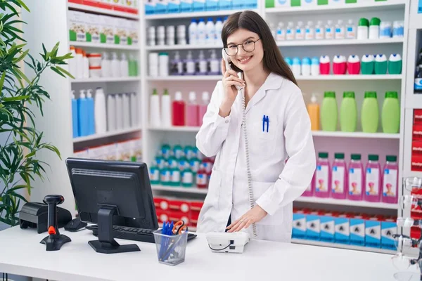 Młoda Biała Kobieta Farmaceuta Rozmawia Przez Telefon Pomocą Komputera Aptece — Zdjęcie stockowe