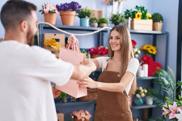 Man and woman customer holding shopping bag at flower shop