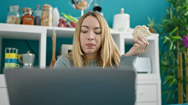Junge Blonde Frau Mit Laptop Isst Reiskuchen Esszimmer — Stockfoto