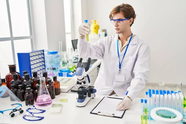 Young Caucasian Man Scientist Holding Test Tube Writing Document Laboratory — Stock Photo, Image