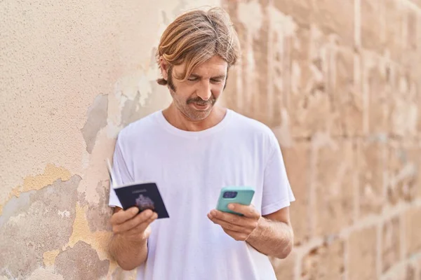 Young Blond Man Using Smartphone Holding Passport Street — 图库照片