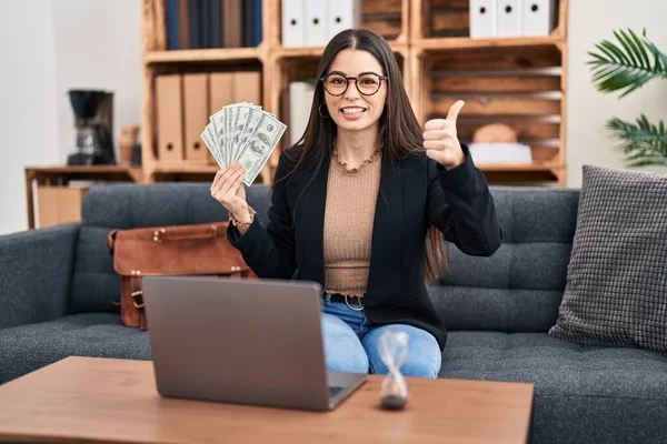 Jovem Trabalhando Escritório Consultoria Segurando Dinheiro Sorrindo Feliz Positivo Polegar — Fotografia de Stock