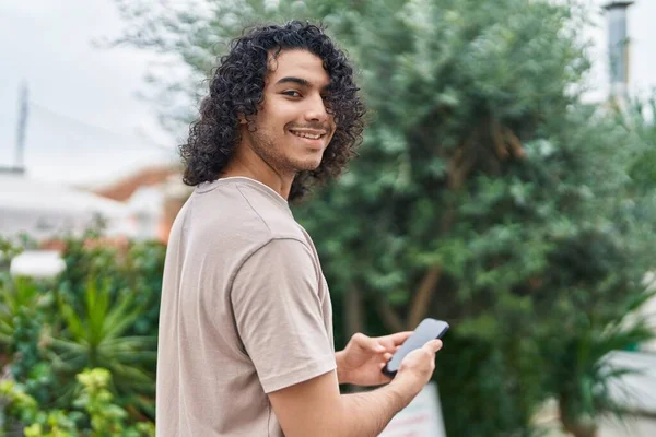 Νέοι Λατίνος Άνθρωπος Χαμογελά Αυτοπεποίθηση Χρησιμοποιώντας Smartphone Στο Πάρκο — Φωτογραφία Αρχείου