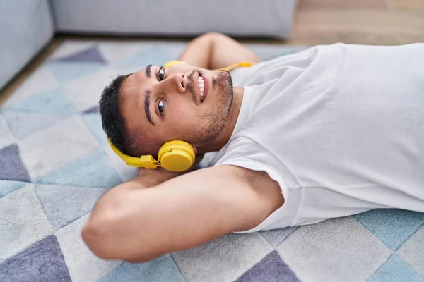 Young Hispanic Man Listening Music Lying Floor Home — Stockfoto
