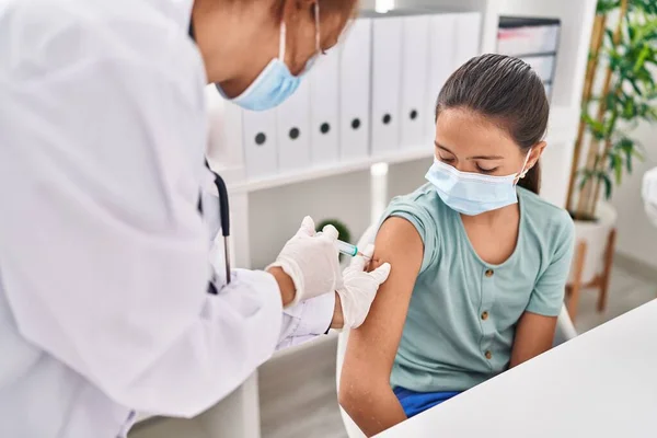 stock image Woman and girl doctor and patient wearing medical mask vaccinating arm at clinic
