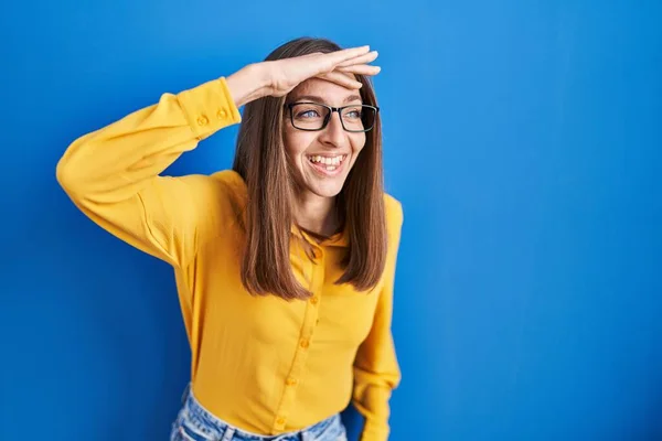 Mavi Arka Planda Duran Gözlüklü Genç Bir Kadın Çok Mutlu — Stok fotoğraf