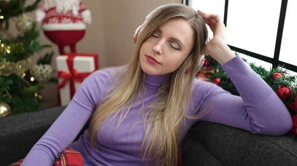 Jong Blond Vrouw Luisteren Naar Muziek Zitten Bank Door Kerstboom — Stockfoto