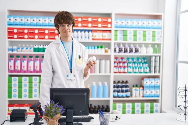 Young Blond Man Pharmacist Using Computer Holding Pills Bottle Pharmacy — Stock fotografie