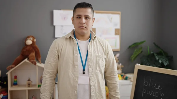 Young Hispanic Man Preschool Teacher Standing Relaxed Expression Kindergarten — Stockfoto