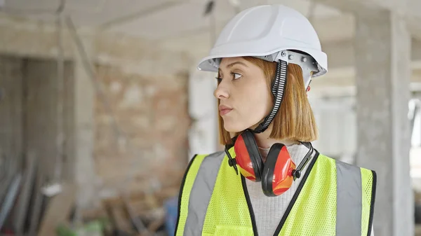 年轻的金发女建筑师站在建筑工地上 表情轻松 — 图库照片