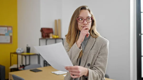 若い白人女性ビジネスワーカーオフィスで緊張した表情で文書を読む — ストック写真