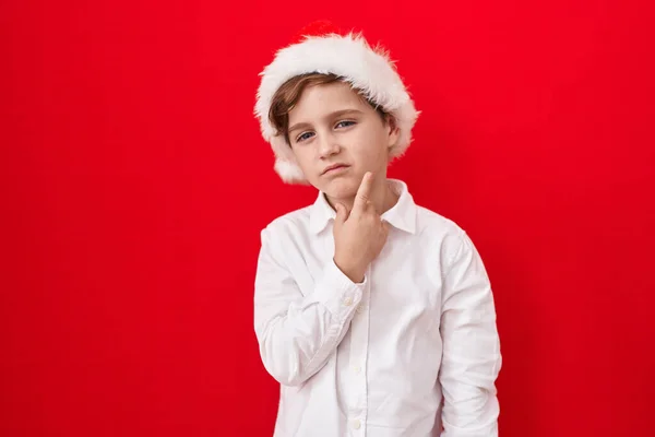 Malý Kavkazský Chlapec Nosí Vánoční Klobouk Nad Červeným Pozadím Myšlení — Stock fotografie