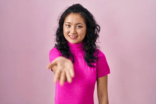 Jonge Aziatische Vrouw Staan Roze Achtergrond Glimlachend Vrolijk Aanbieden Palm — Stockfoto