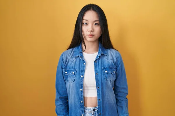 Mladá Asiatka Stojící Nad Žlutým Pozadím Uvolnila Vážným Výrazem Tváři — Stock fotografie
