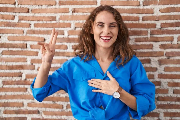 Beautiful Brunette Woman Standing Bricks Wall Smiling Swearing Hand Chest — Stock Photo, Image